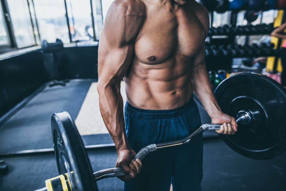 Un hombre entrenando con una barra en el gimnasio