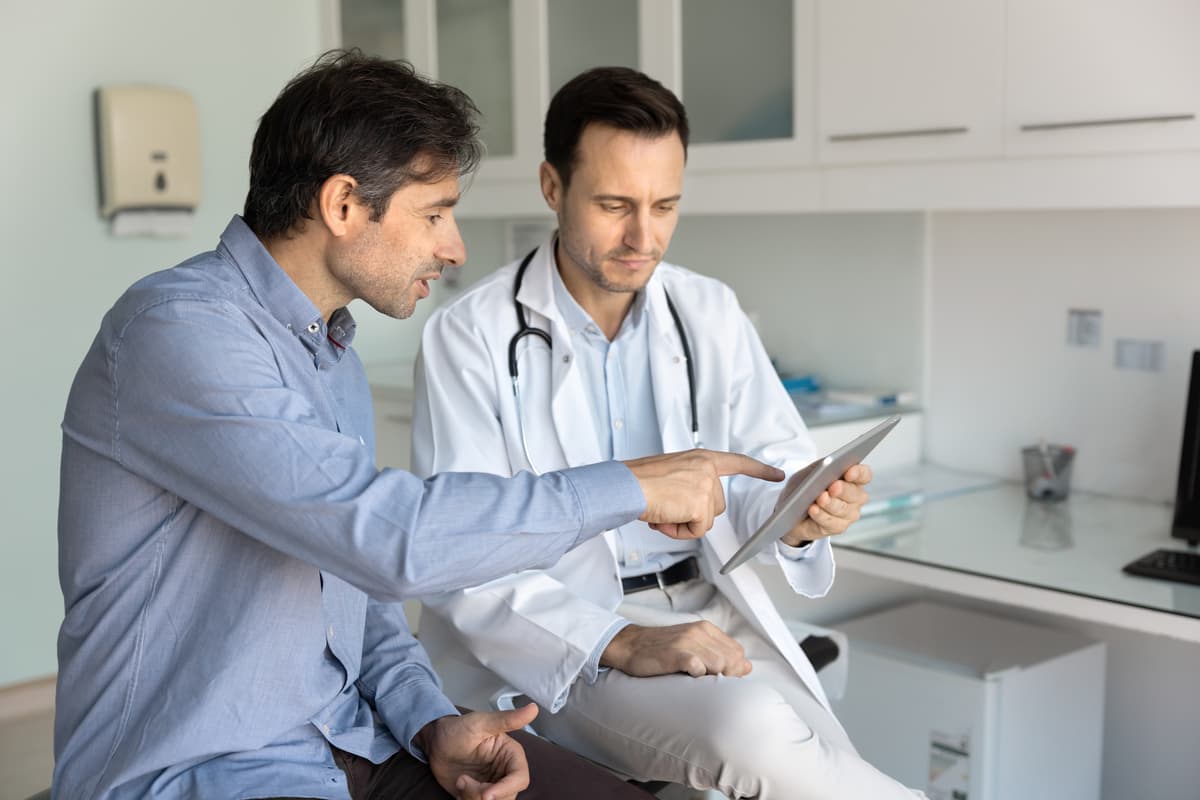 Un hombre revisando resultados con un médico
